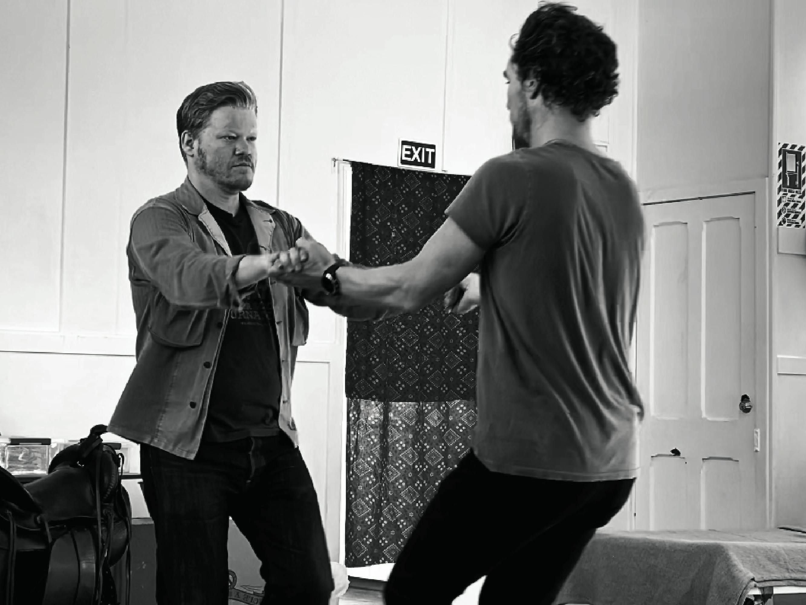 Jesse Plemons and Benedict Cumberbatch dance together in this black-and-white shot.