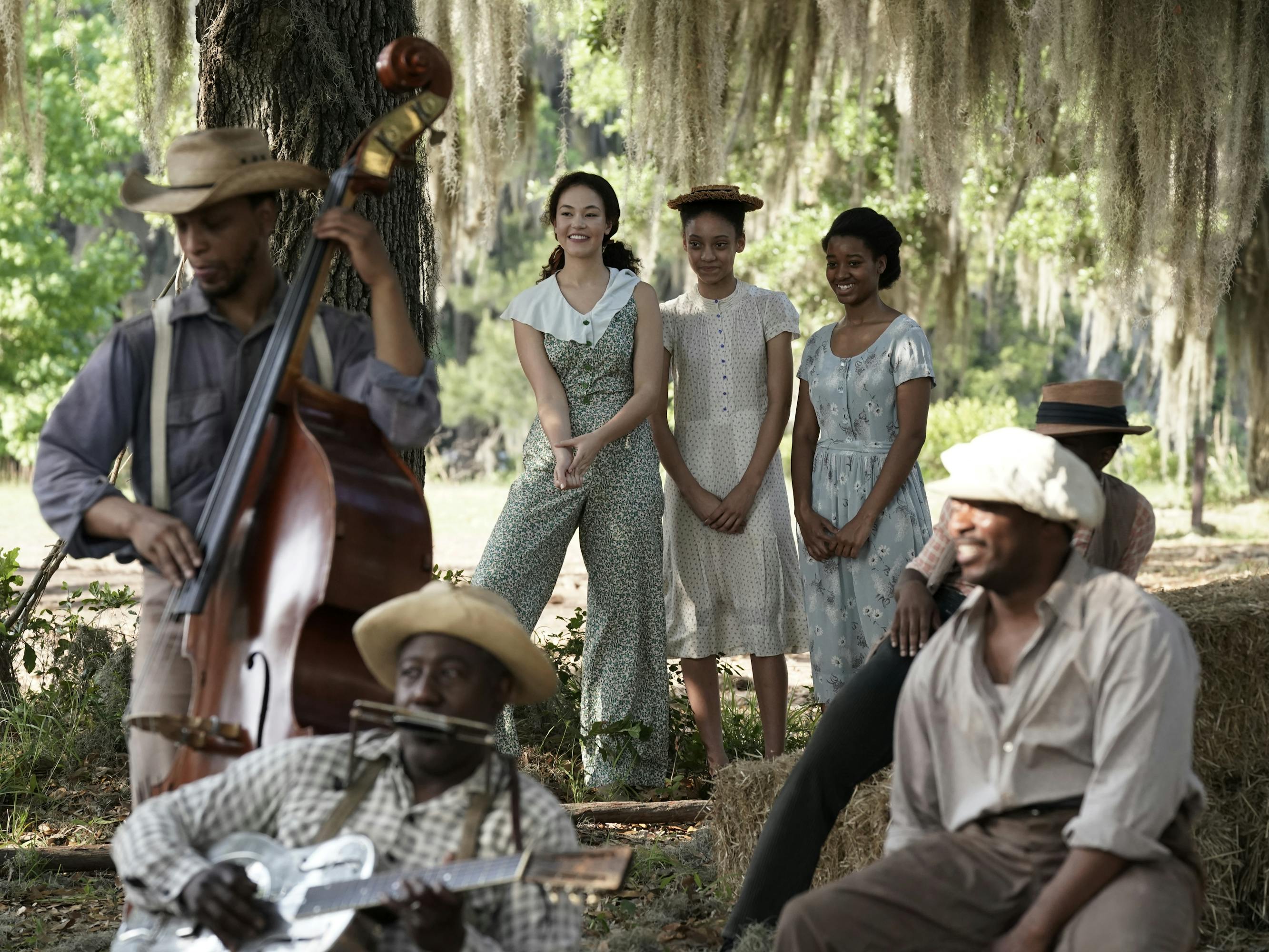 Leanne (Solea Pfeiffer) and a musical trio stand underneath a weeping willow in a soft light.