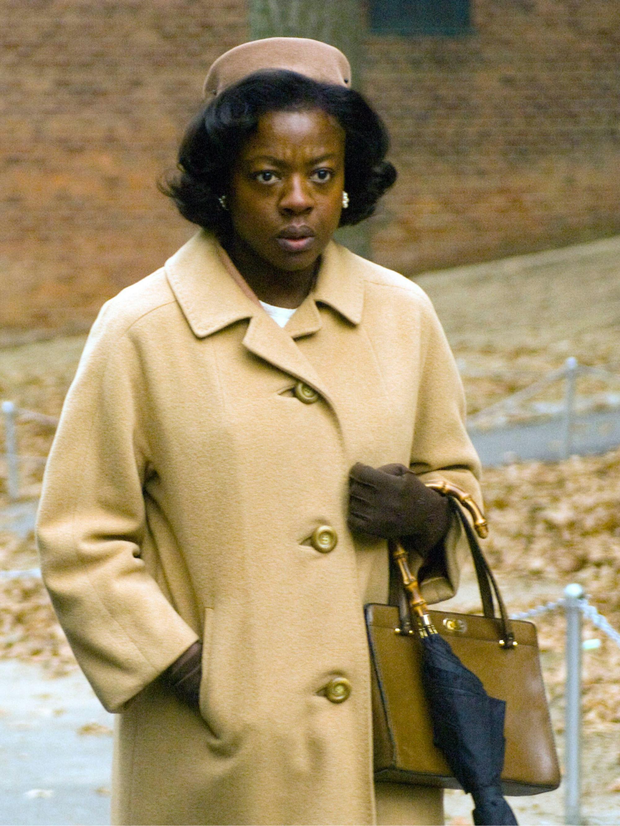 Viola Davis wears a tan pillbox hat and beige peacoat in a scene from Doubt. 