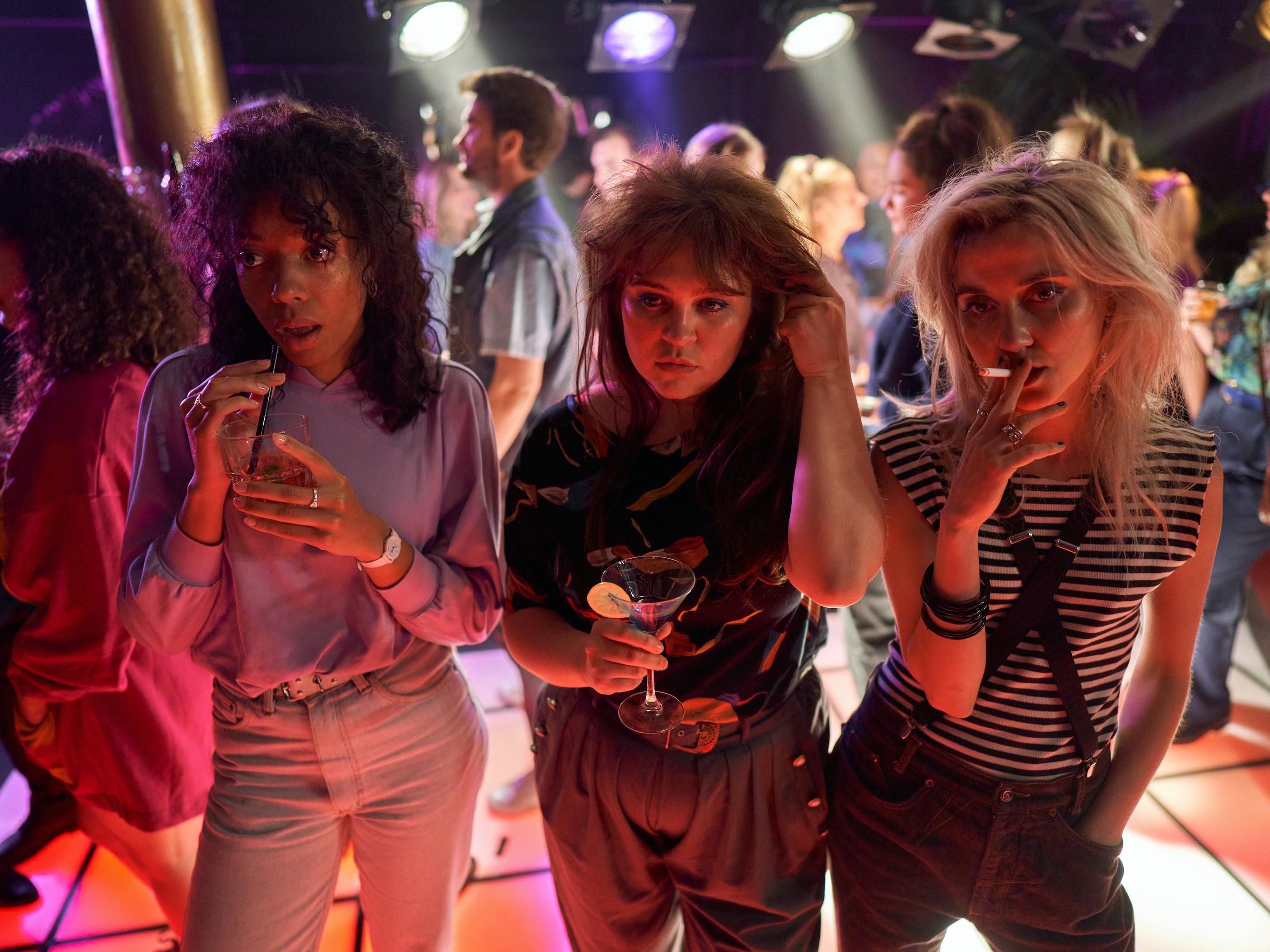 Joy Delima, Ayla Satijn, and Julia Akkermans stand together looking cool in the middle of the dancefloor.