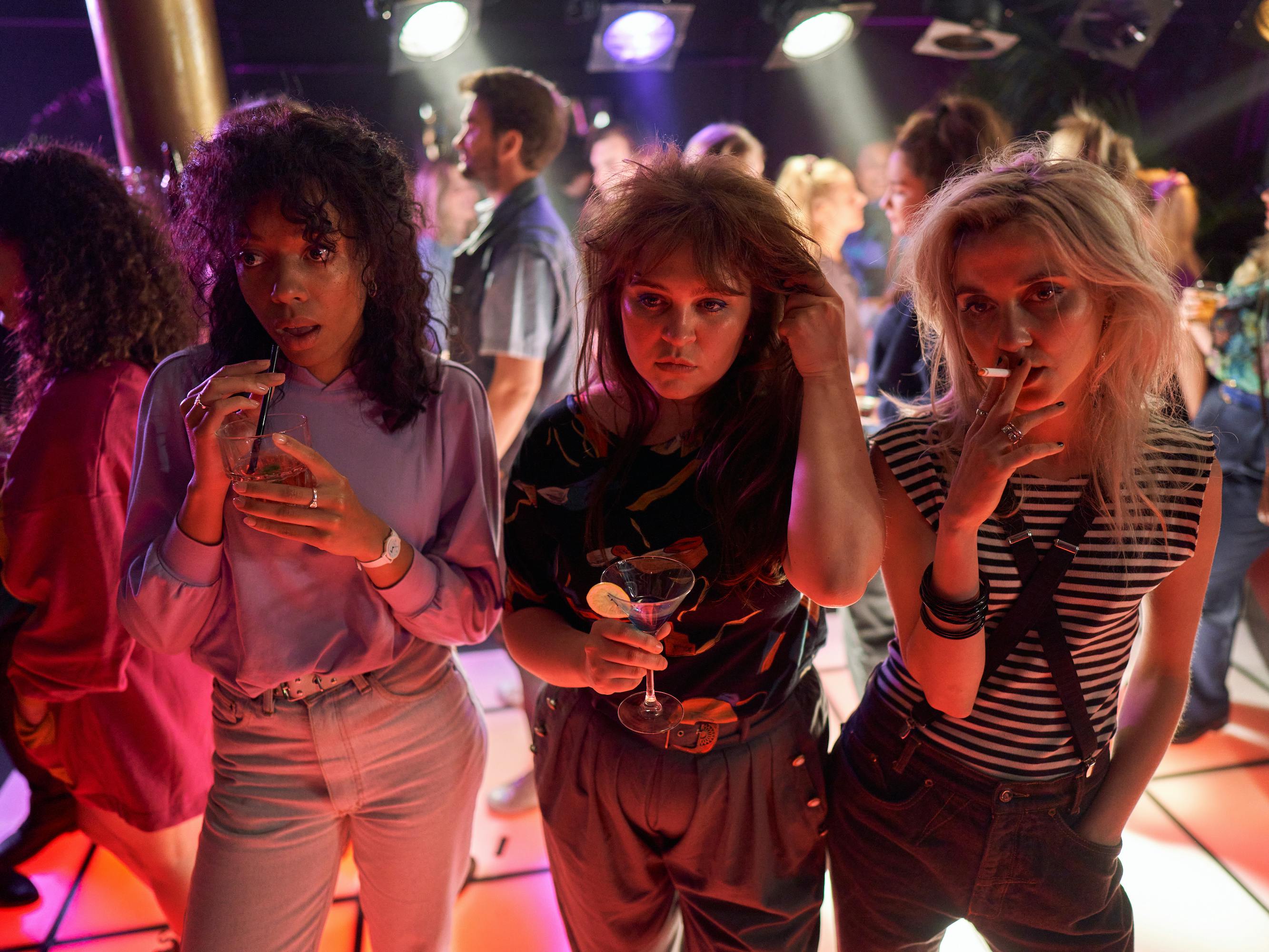 Joy Delima, Ayla Satijn, and Julia Akkermans stand together looking cool in the middle of the dancefloor. 