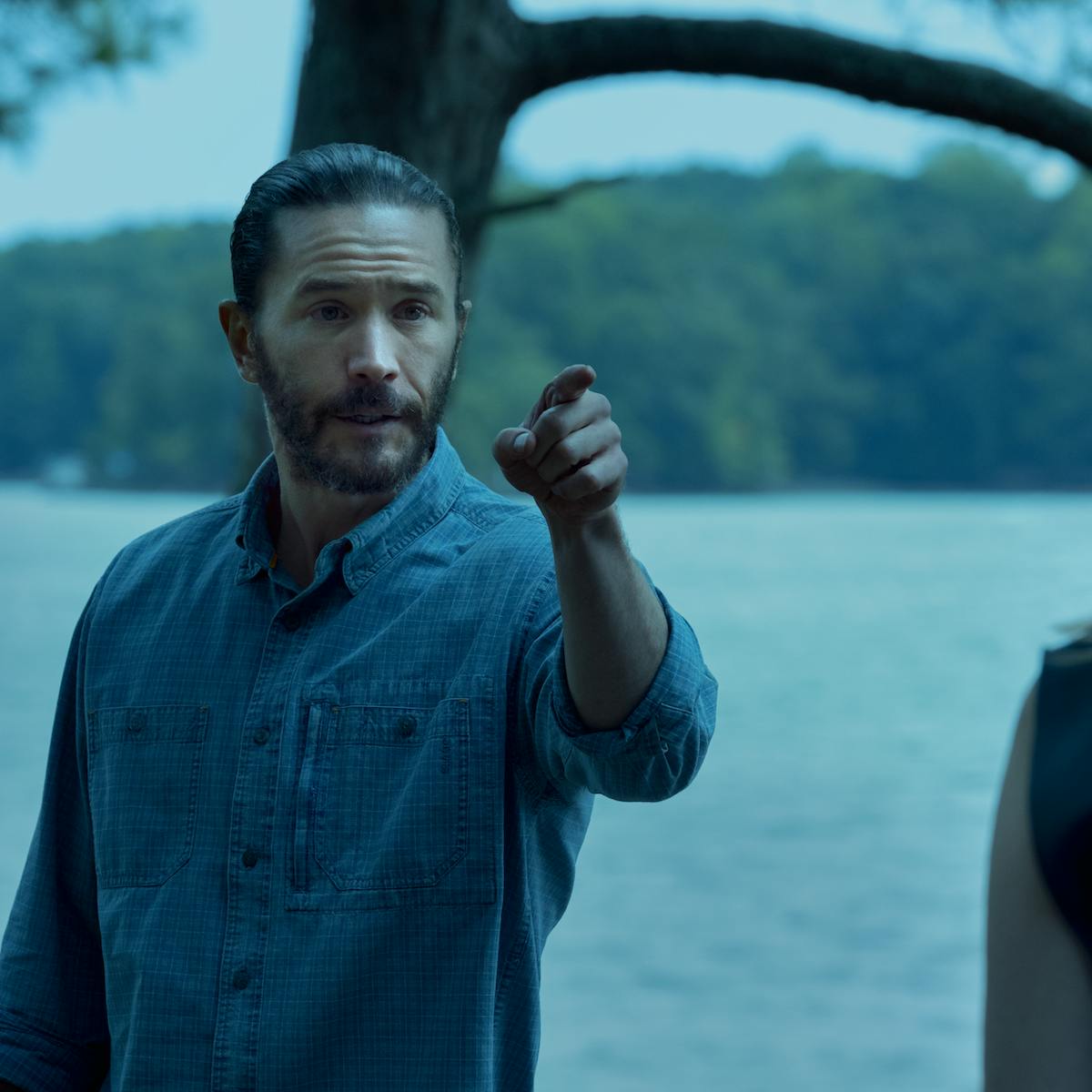 Ben Davis (Tom Pelphrey) points at Laura Linney beside a lake.