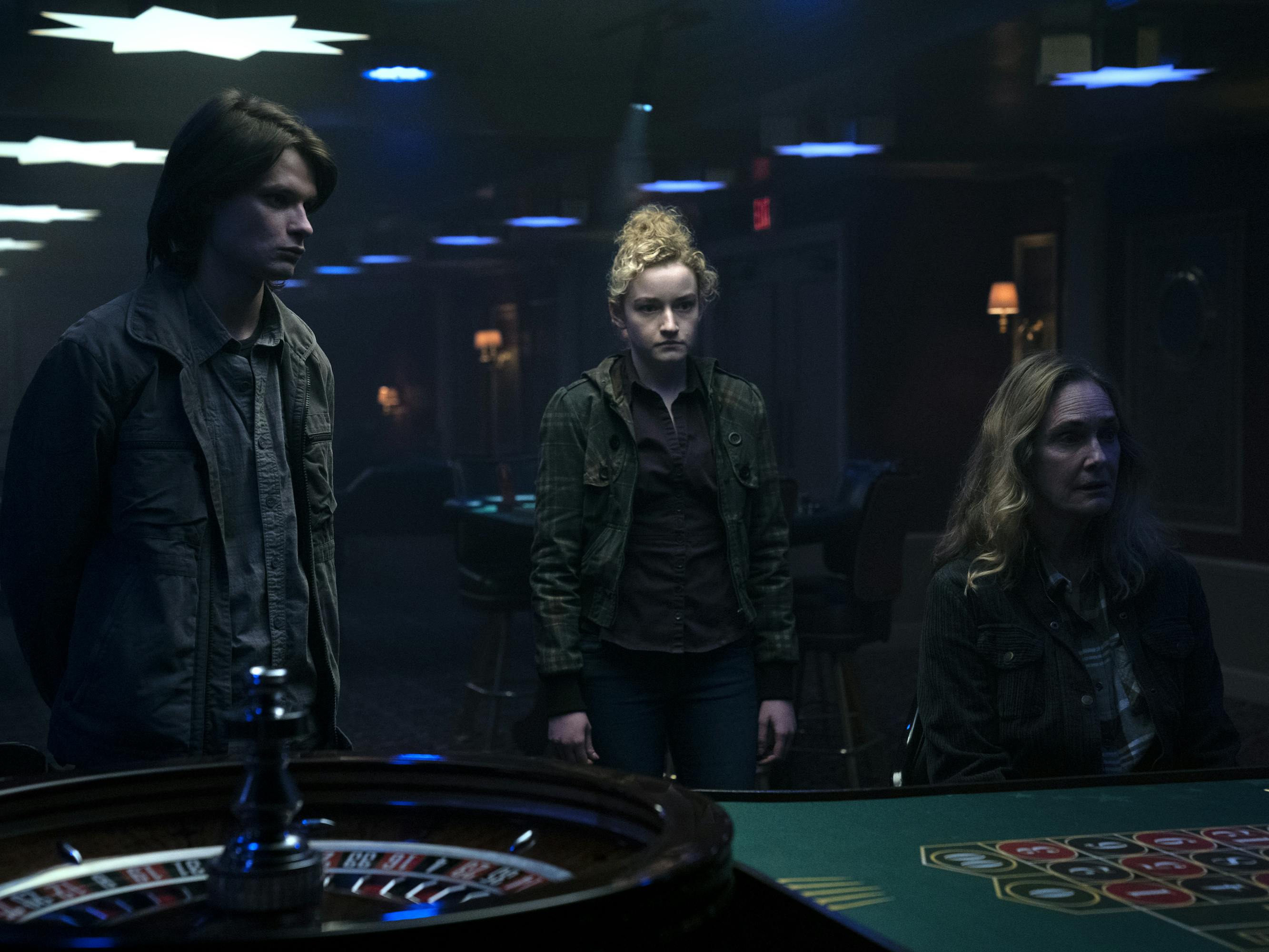 Wyatt Langmore (Charlie Tahan), Ruth Langmore (Julia Garner), and Darlene Snell (Lisa Emery) stand around in a dark casino.