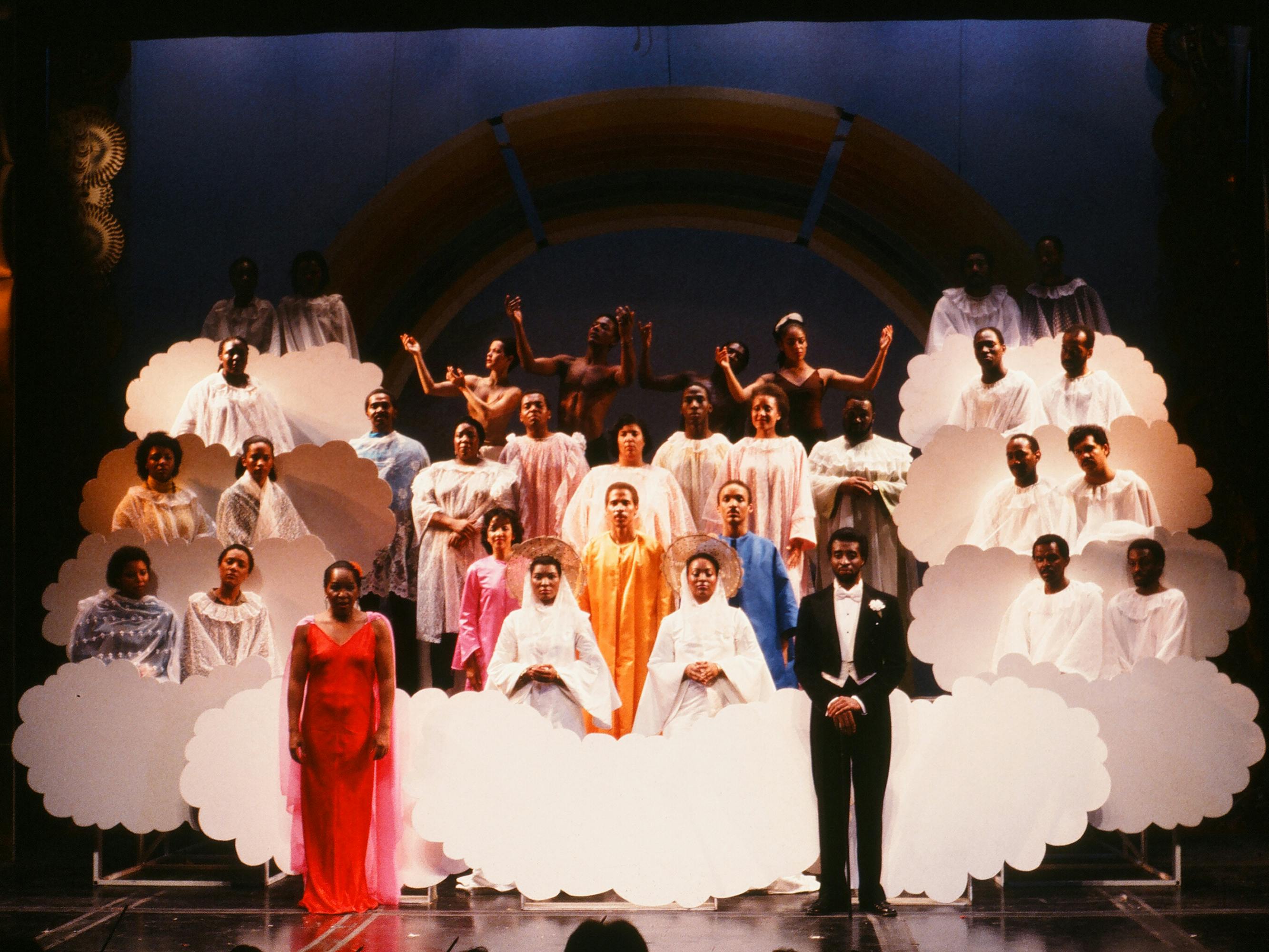 Four Saints in Three Acts onstage: singers wear long dresses and fluffy white clouds.