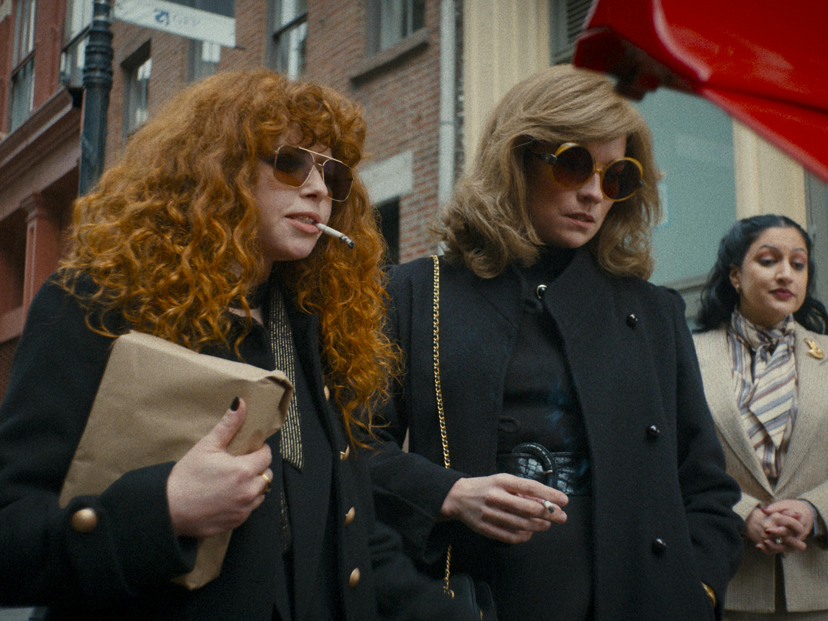 Nadia Vulvokov (Natasha Lyonne) and Young Ruth Brenner (Annie Murphy) walk together in dark coats.