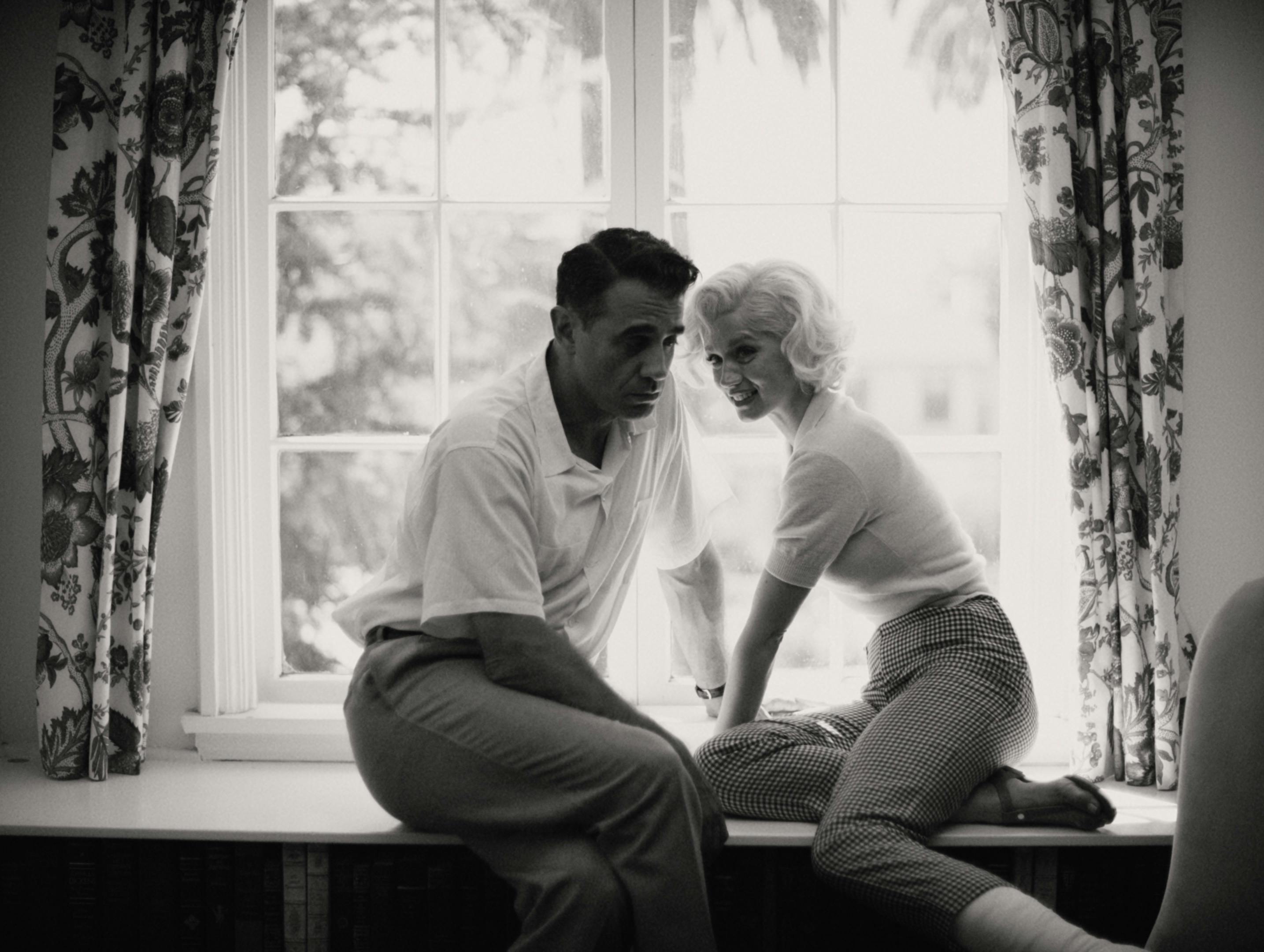 Bobby Cannavale and Marilyn Monroe sit in a window sill together in this black-and-white shot.