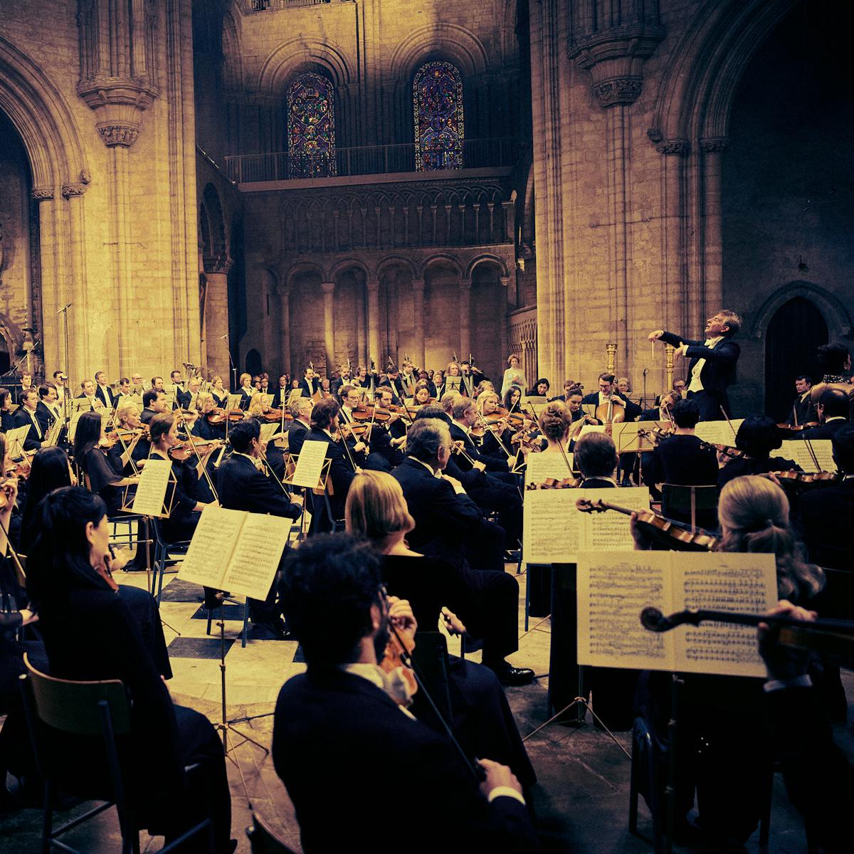 Leonard Bernstein (Bradley Cooper) conducts an orchestra in a grand hall.
