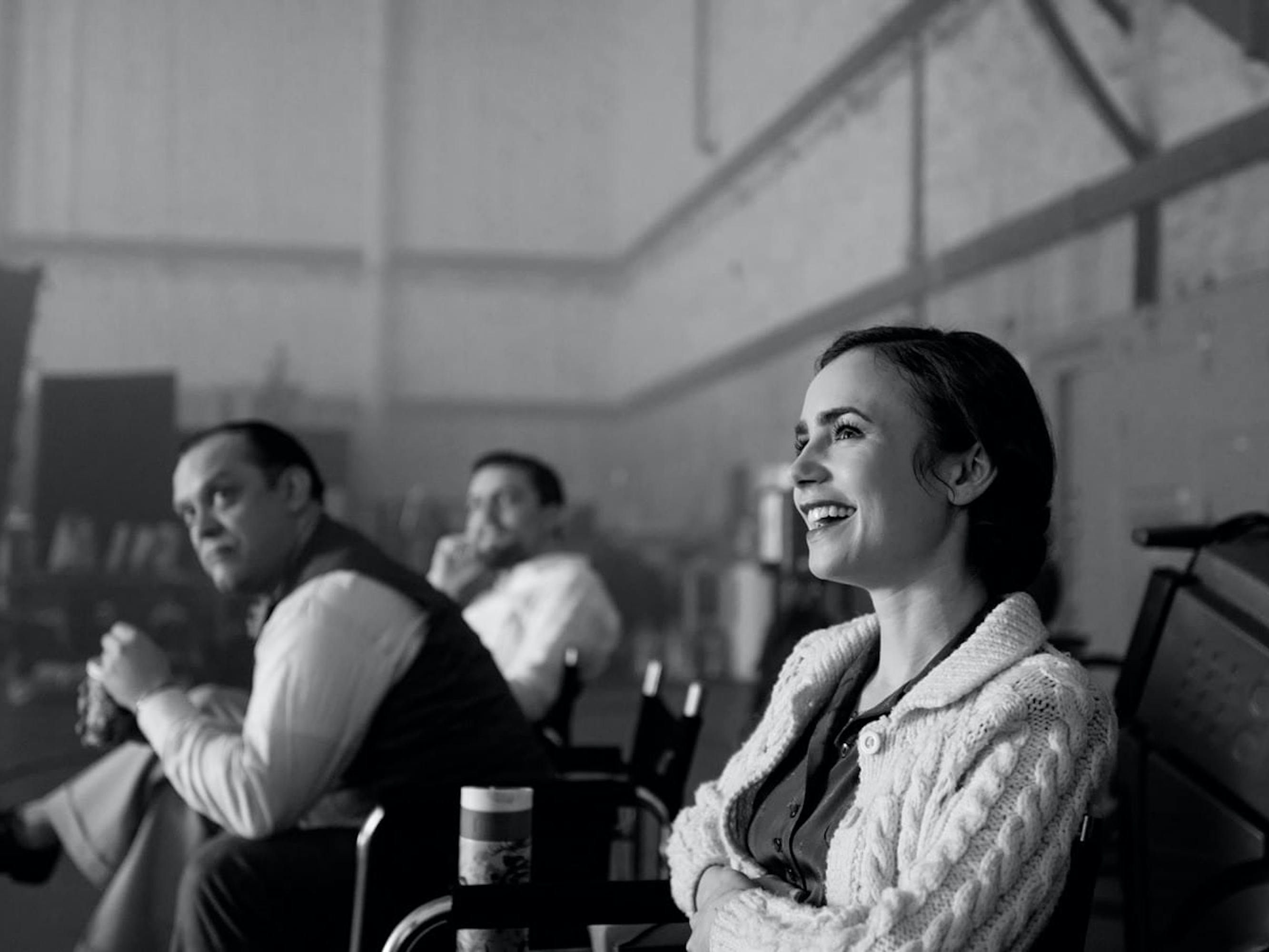 Lily Collins enjoys a moment on the set of Mank. Who’s that way in the back? It must be Orson Welles himself!