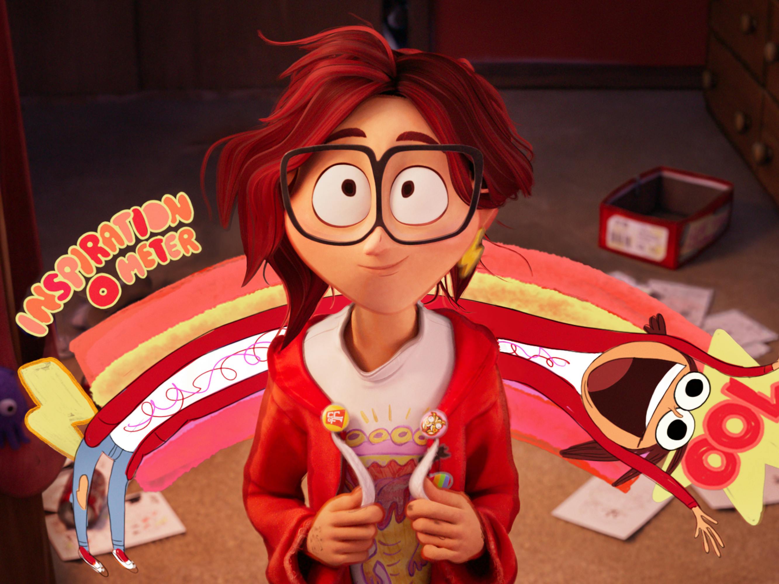 Katie Mitchell wears a red hoodie, big glasses, and a white t-shirt. Behind her is elongated hotdog that reads "Inspiration O Meter."