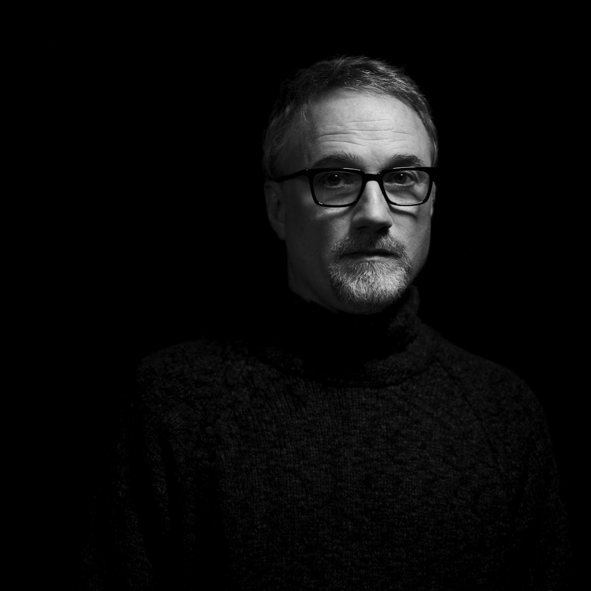 In this dark picture, all you can see is David Fincher's face, wearing a pair of black glasses.