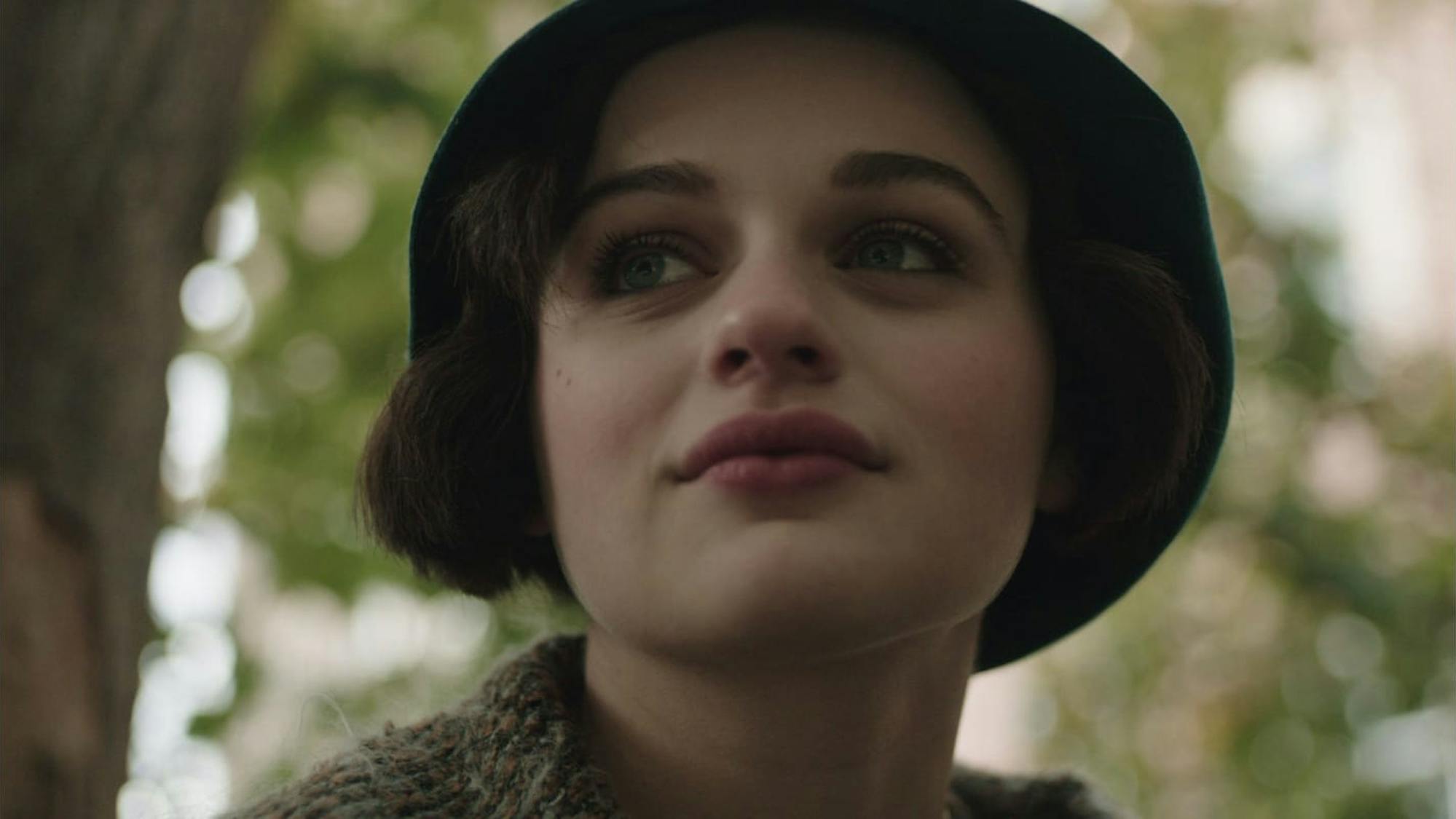 Bessie (Joey King) in Radium Girls wears a hat and red lipstick in this shot framed by etheral nature views.