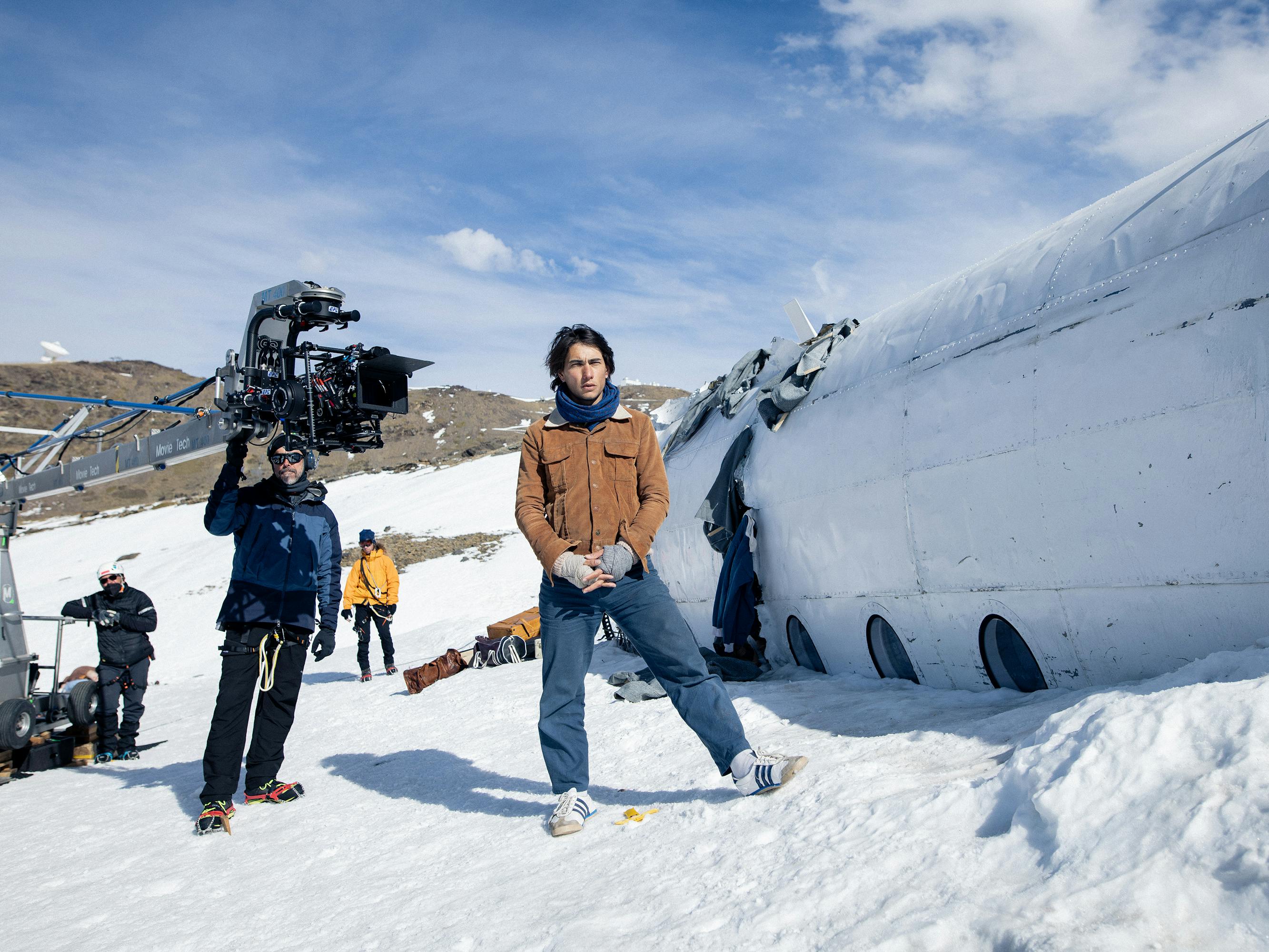 Behind the scenes with Enzo Vogrincic. He stands by a plane set on a snowy, cold set.