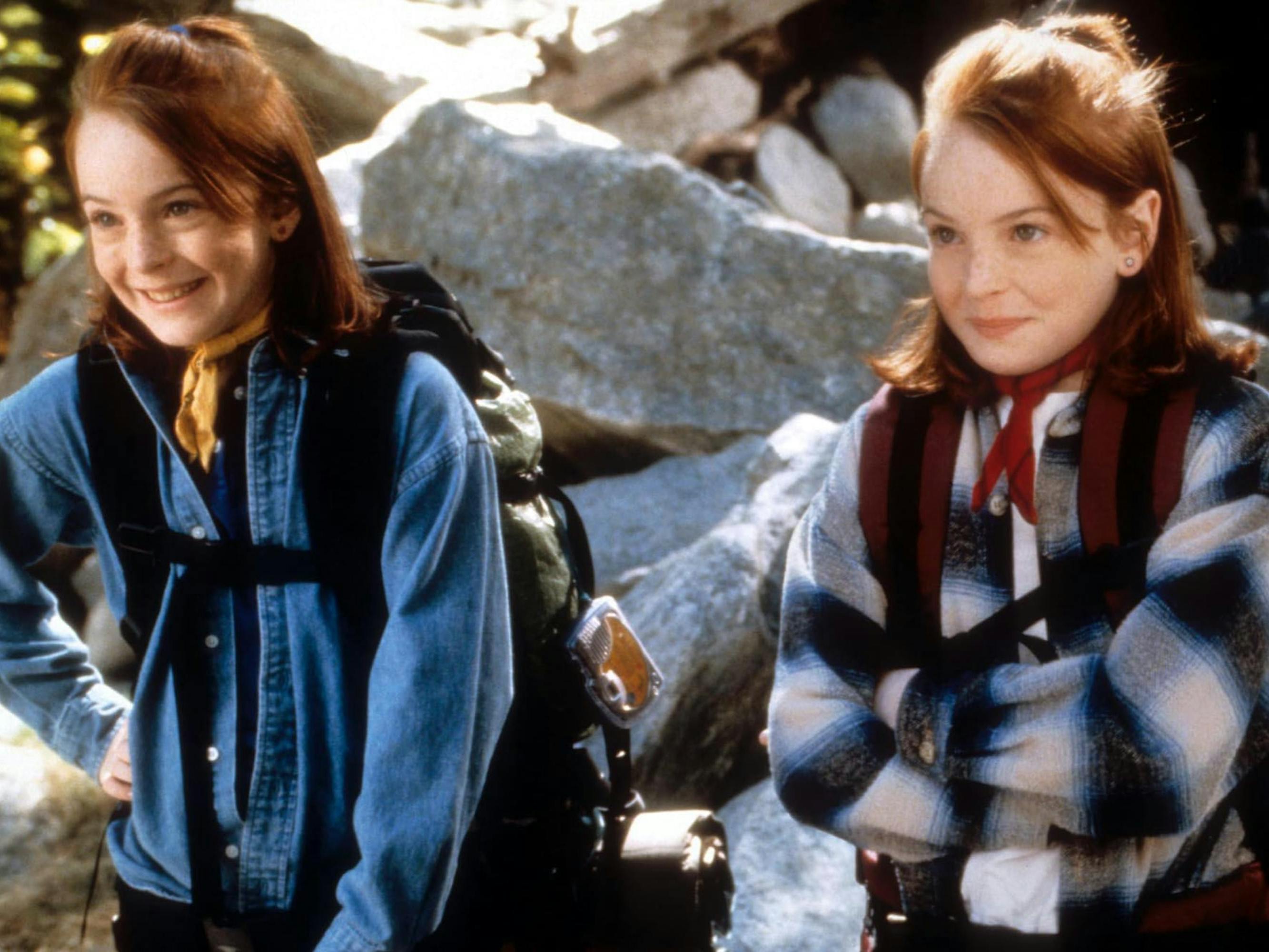 Halle Parker (Lindsay Lohan) and Annie James (Lindsay Lohan) in The Parent Trap. The two girls wear western jackets with adorable bandanas tied around their neck in this rocky outdoors scene.