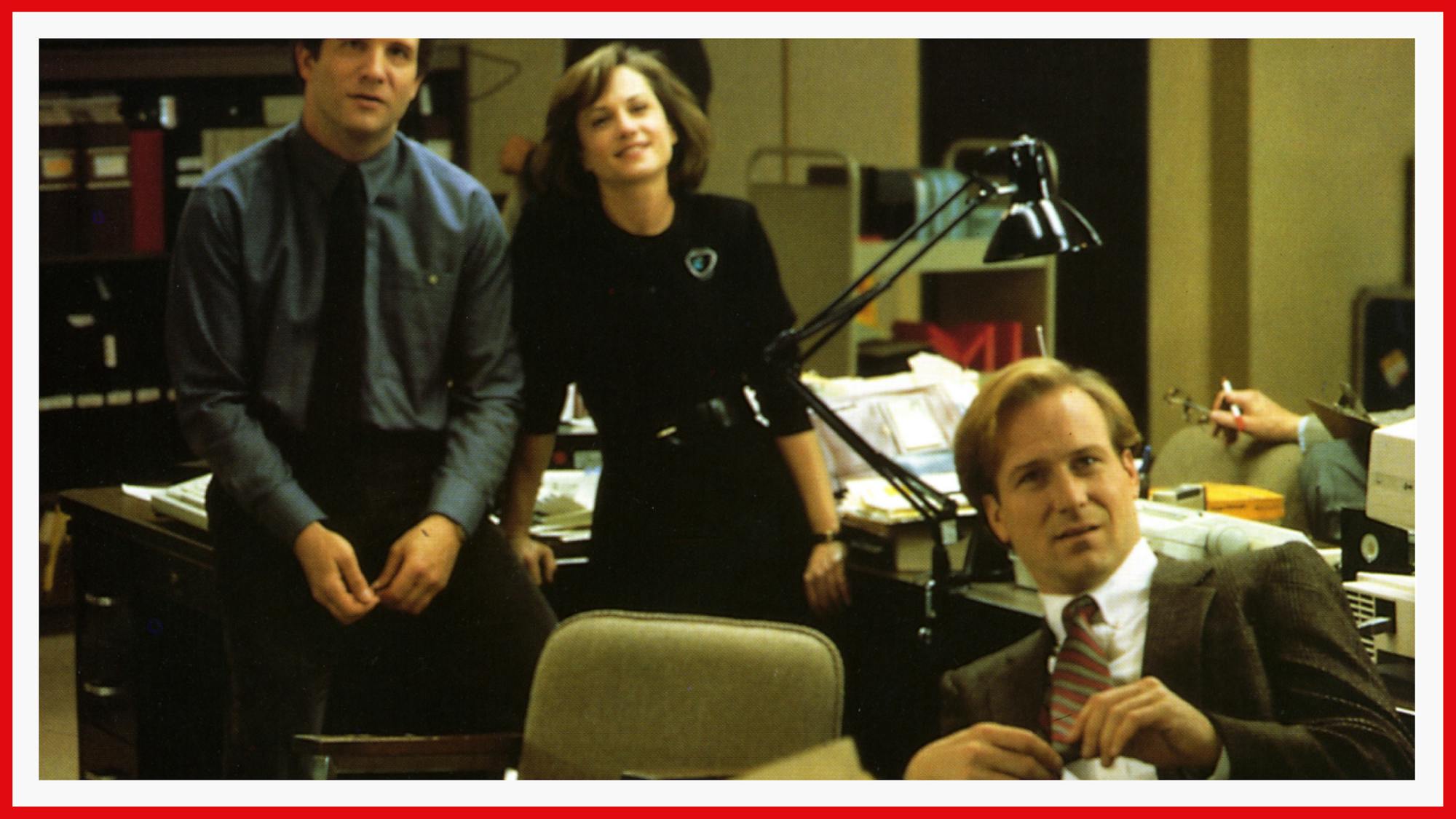Brooks, Hunter, and Hurt in a scene from the film. They are pictured in a messy newsroom office.