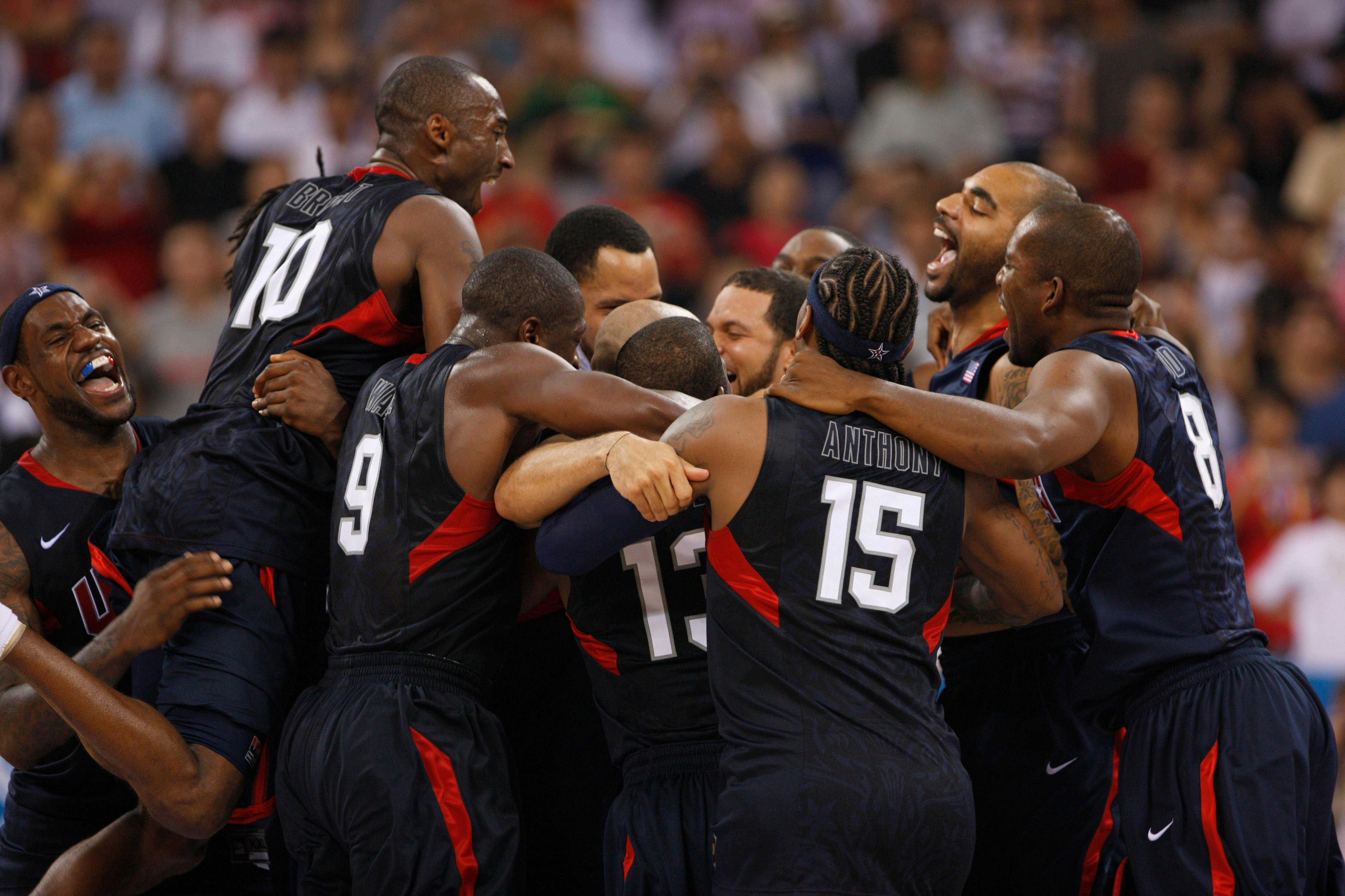 The Redeem Team hug excitedly in black and red uniforms.