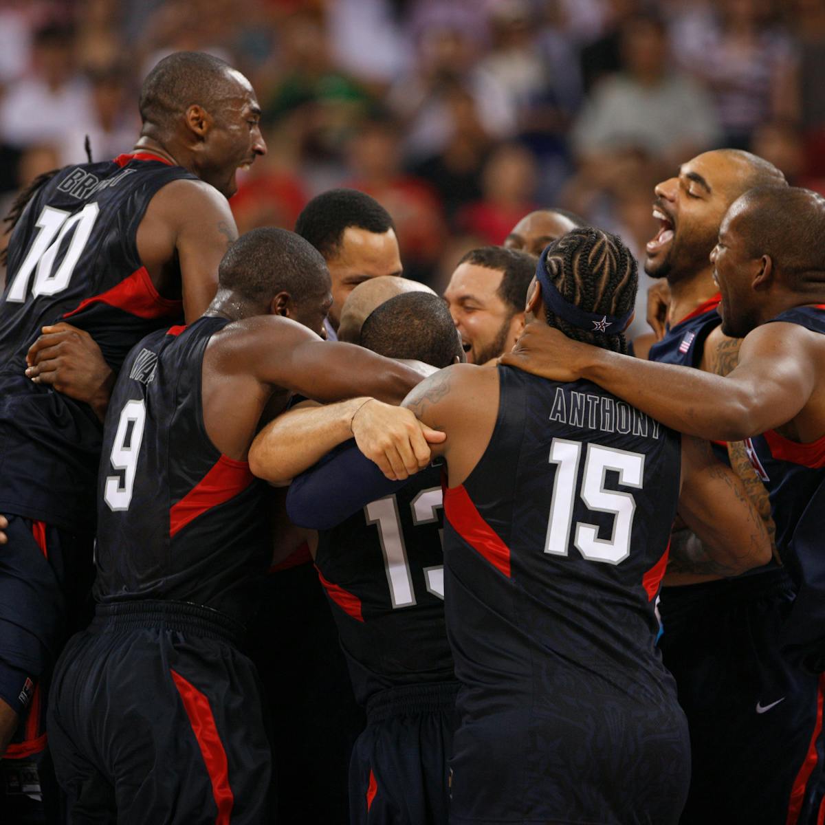 The Redeem Team hug excitedly in black and red uniforms.