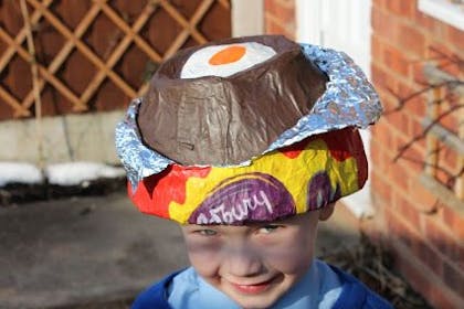 Little boy wearing a cadburys creme egg Easter bonnet