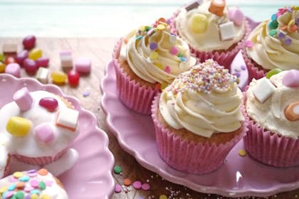 Decorated cupcakes with buttercream icing, cake sprinkles, Dolly Mixture and pink cupcake cases