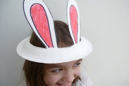 Girl wearing paper plate bunny ears hat