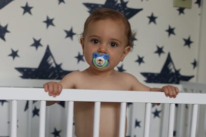 Baby standing up in cot