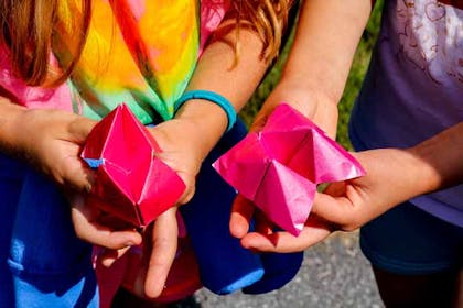 Two girls playing with paper fortune tellers