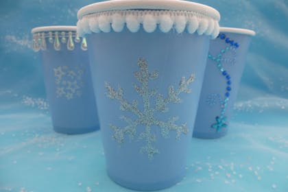 Frozen themed blue party cups with silver snowflakes for decoration