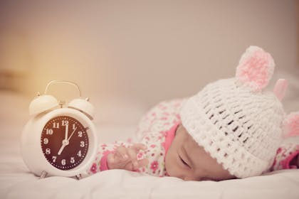 baby girl sleeping with alarm clock