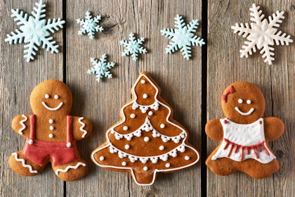 Gingerbread family and Christmas tree served with  icing and snowflakes decoration