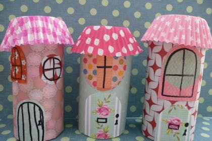 Toilet roll tubes turned into fairy houses with wallpaper scraps and cupcake cases for the roof