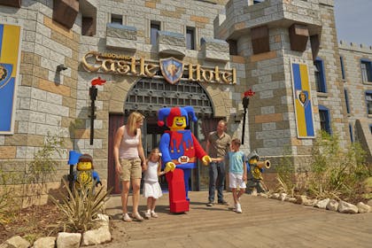 Family with Lego mascot in front of Castle Hotel at Legoland Windsor