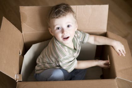 Child sitting in a cardboard box