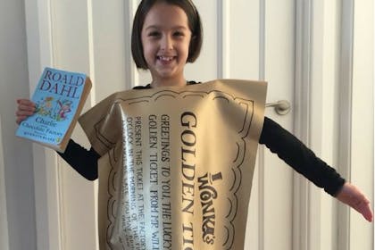 Little girl dressed as Roald Dahl's golden ticket from Charlie and the Chocolate Factory
