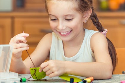 Child sewing with needle and thread