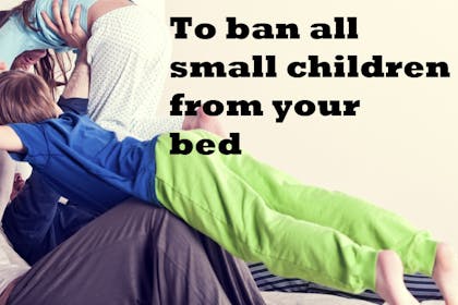 parents playing with children on bed