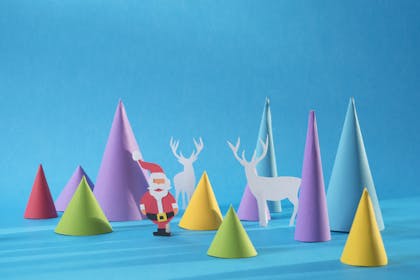 paper cone shapes made to look like christmas trees with a small santa and reindeer