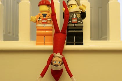 lego men holding elf upside down