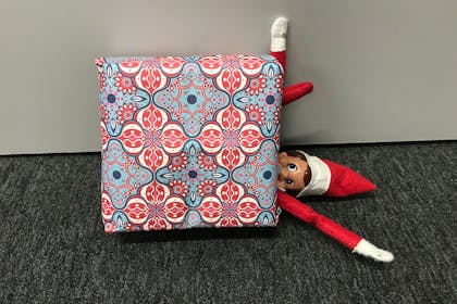 Elf on the Shelf hides in a wrapped Christmas present