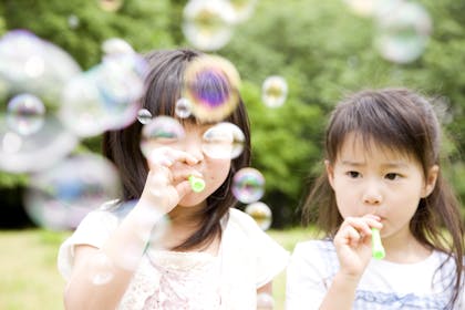 Two young girls blowing bubbles