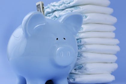 blue piggy bank and nappies on blue background