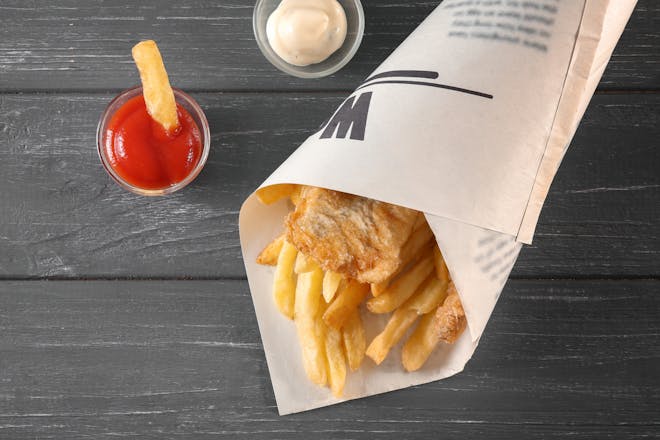 Fish and chips takeaway in newspaper with ketchup