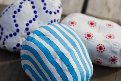 Rocks painted with stripes, dots and sun patterns