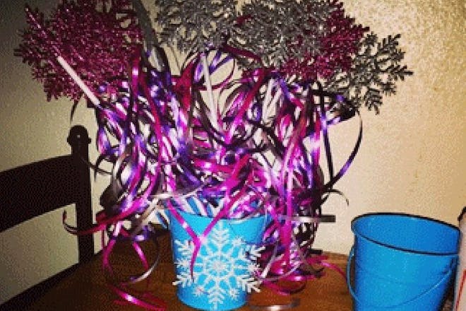 Pink ribboned fairy wands in bucket with snowflake decoration for Frozen party