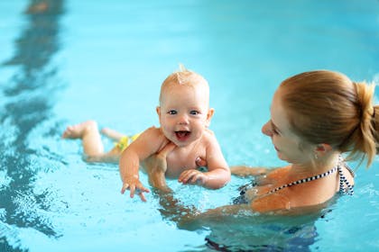 Baby swimming with mum