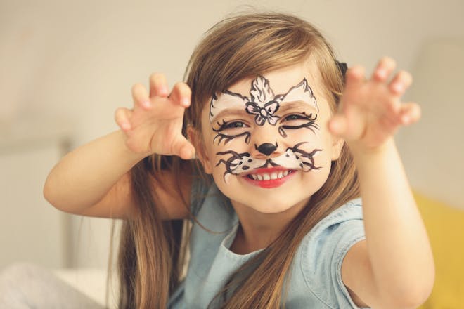 Child with her face painted as a cat