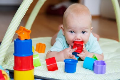 baby playing with colourful blocks