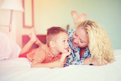 mum and little boy talking on bed