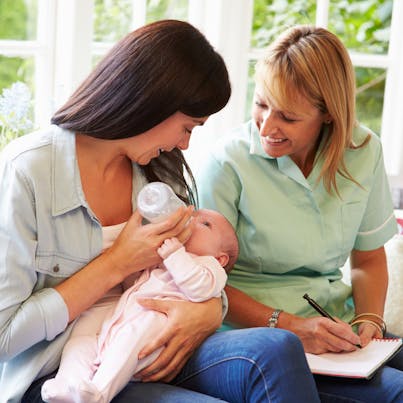 health visitor at home with a mum and baby