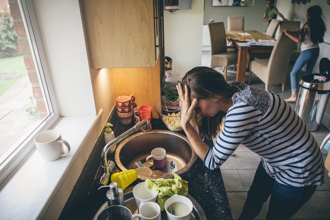 woman leaning over kitchen sink
