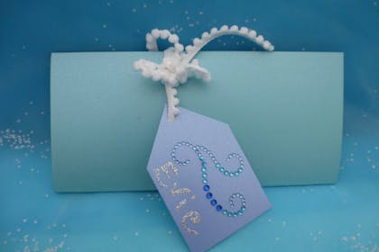 Frozen party invitation made from blue card with gems and silver pen for decorations