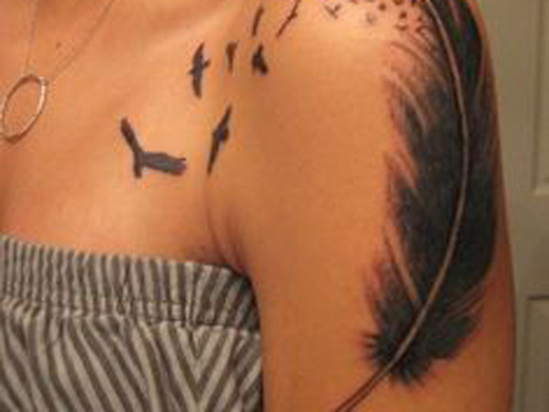 Abstract style tattoo of many birds flying from the